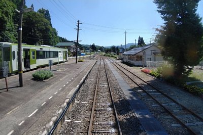 キハ100系気動車と駅舎と構内踏切